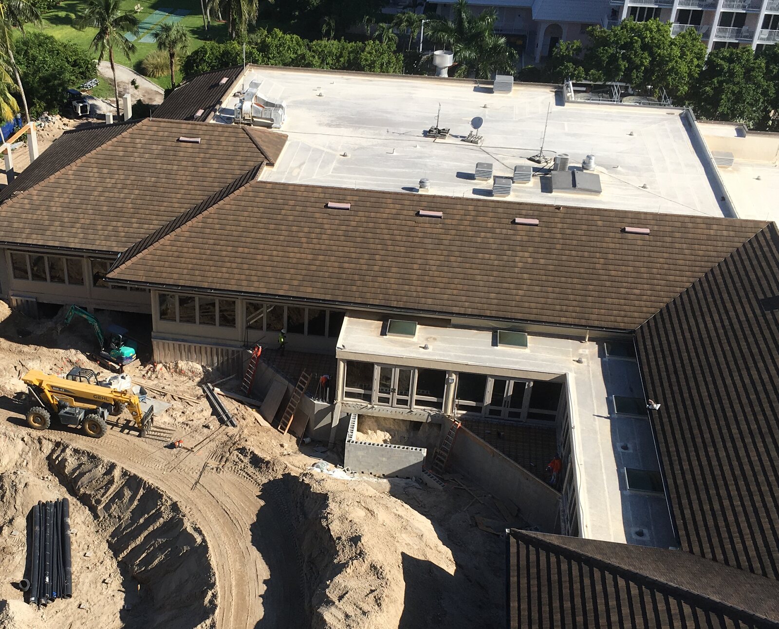 Aerial view of a commercial tile roof and flat roof section under construction