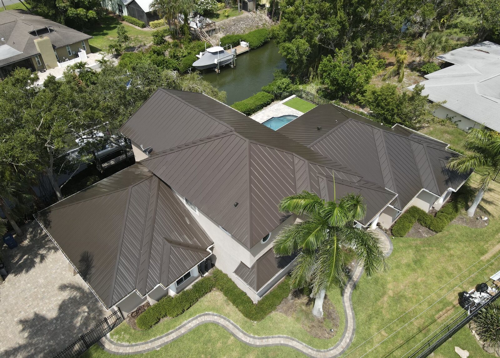 5V crimp metal roof on a canal-front Southwest Florida home — exposed-fastener panel with five V-crimps per sheet
